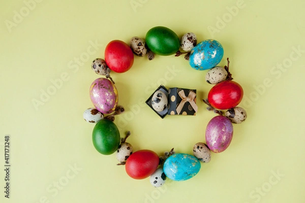 Fototapeta Gift and painted eggs Easter Frame in circle shape on a yellow background. Copy space, Top view