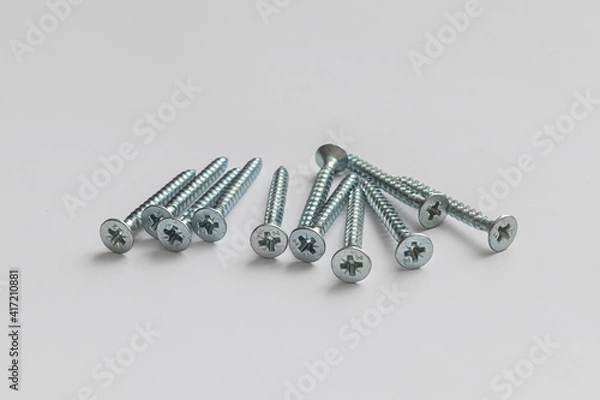 Fototapeta Handful of galvanized self-tapping screws on a white background