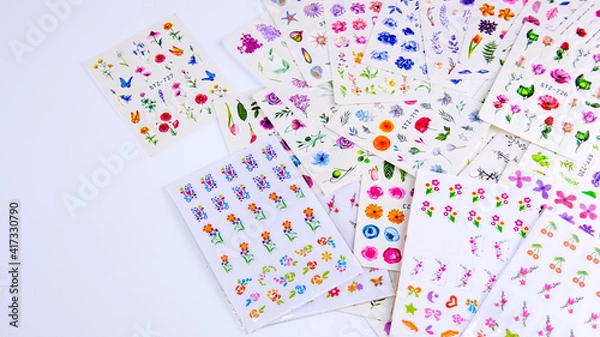 Fototapeta multicolored stickers for manicure on a white background, background