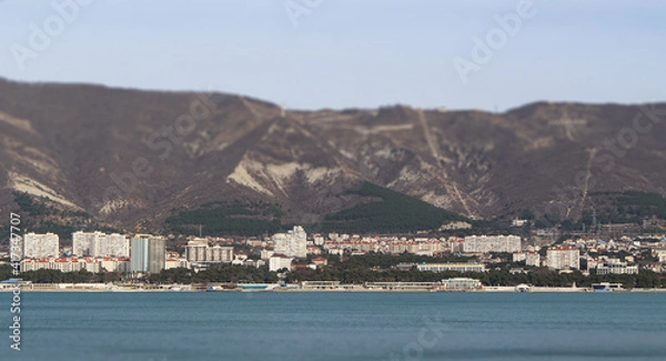 Obraz Spring view of the resort city of Gelendzhik, many buildings at the foot of the majestic mountains, warm and slightly cloudy weather and the beauty of nature. Russia, Black Sea coast