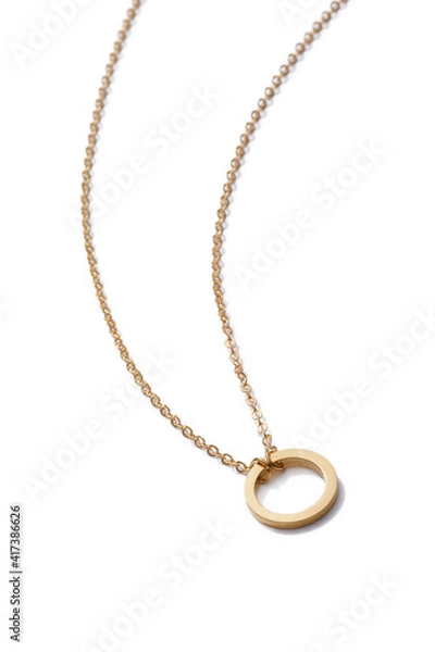 Fototapeta Cropped close-up of elegant golden necklace with flat silver ring. The stylish jewelry is isolated on the white background. 
