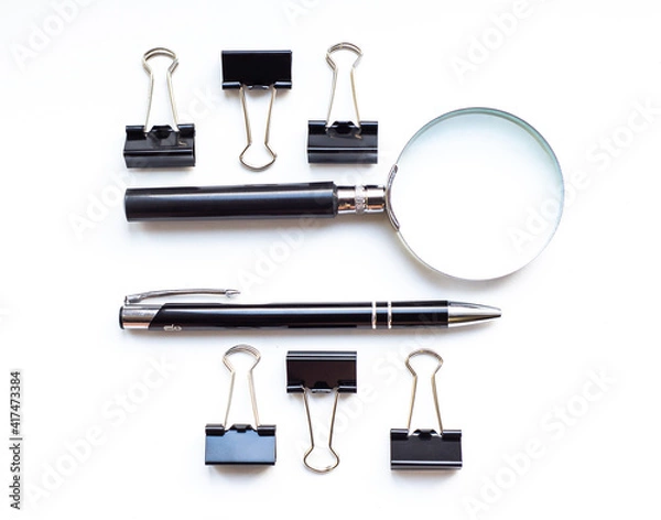 Fototapeta White office desk with magnifying glass, pen and clip for paper with copy space. Accounting work space