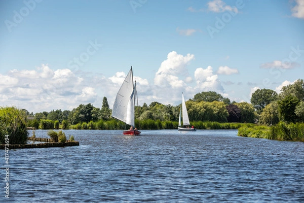 Fototapeta Sailboats on the Kagerplassen  (Boerenbuurt) with people sailing in the South-Holland municipality of Rijpwetering in the Netherlands. On a beautiful day with a blue cloudy sky.