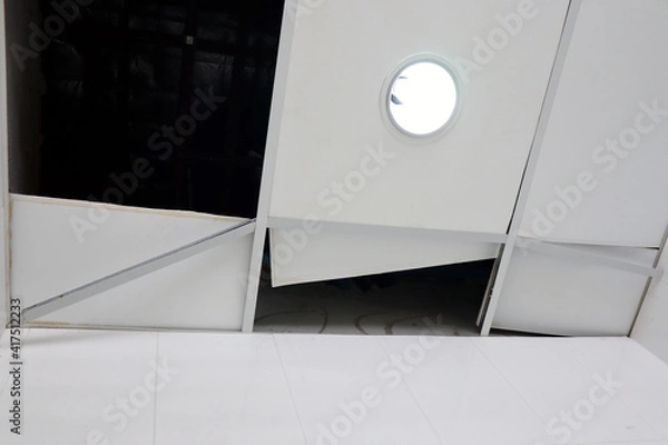 Fototapeta The ceiling was broken due to rain stormy winds. The ceiling was destroyed, waiting to be repaired by skilled technicians. Used for construction to protect the head. Architecture and engineering work.