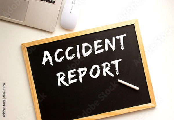 Fototapeta Text ACCIDENT REPORT written in chalk on a slate board. Office desk.