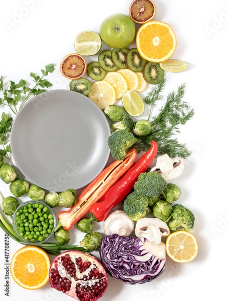 Fototapeta Empty plate with bright healthy vegetables on an isolated background Top view on a healthy, grocery background.