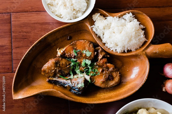 Obraz Beautiful wooden plate is serving a Vietnamese dinner with a food dish called " Ca Kho To " (Caramelized Fish) served with white rice
