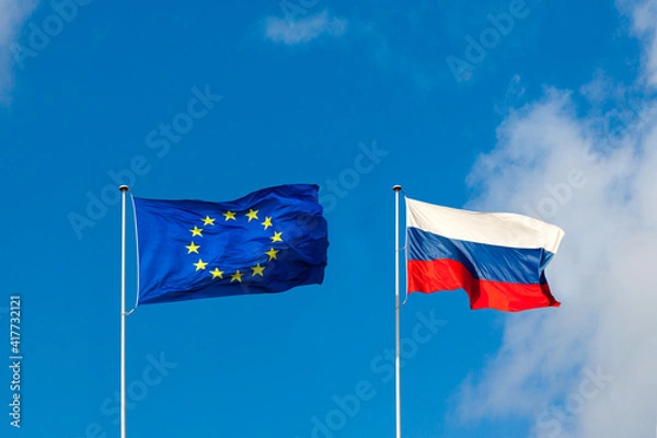 Fototapeta EU flag and Russia flag are on blue sky. Concept relations between Europe and Russia