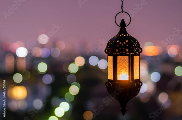 Fototapeta Hanging lantern with night sky and city bokeh light background for the Muslim feast of the holy month of Ramadan Kareem.