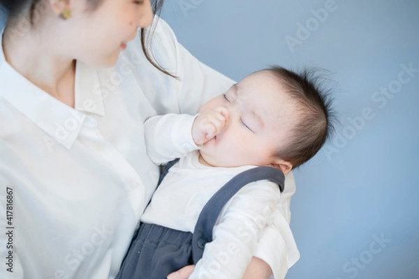 Obraz 寝ている赤ちゃんを抱っこするお母さん
