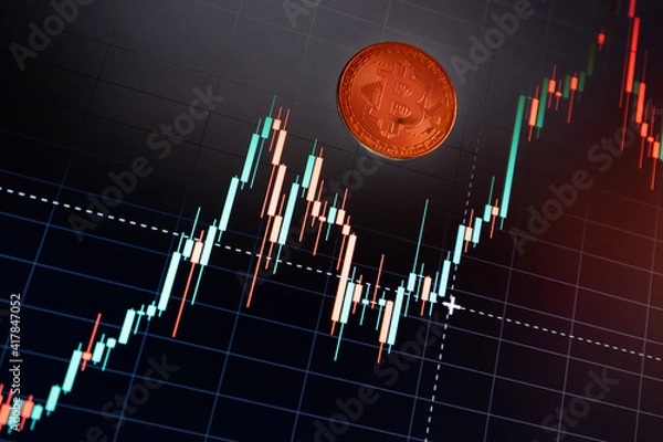 Fototapeta Bitcoin cryptocurrency coin on the background of the exchange chart
