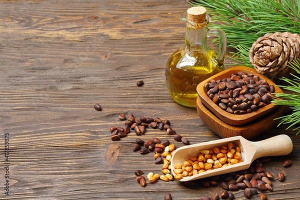 Obraz Cedar cones, nuts and cedar nut oil isolated on a wooden table