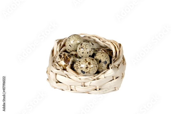 Obraz Boiled spotted quail eggs in a wicker basket, isolated on white background.  Healthy Food Products Concept.