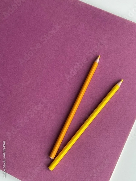 Obraz Colored pencils on purple paper album on white table. Artist, art and hobby. Drawing and painting