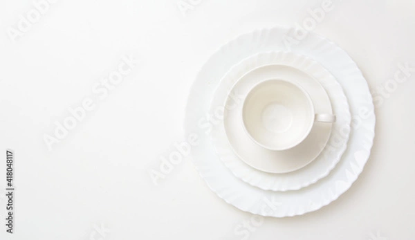 Obraz Three white plates of different sizes on top of each other. The last one has a coffee cup on it. Concept - healthy food, diet. Copy space