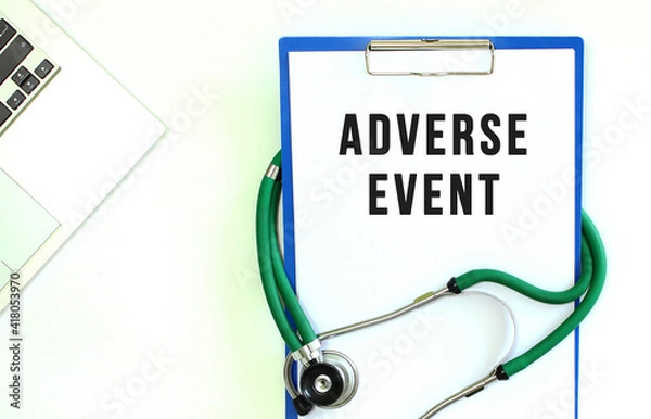 Fototapeta Stethoscope and clipboard with ADVERSE EVENT text on white sheet of paper.
