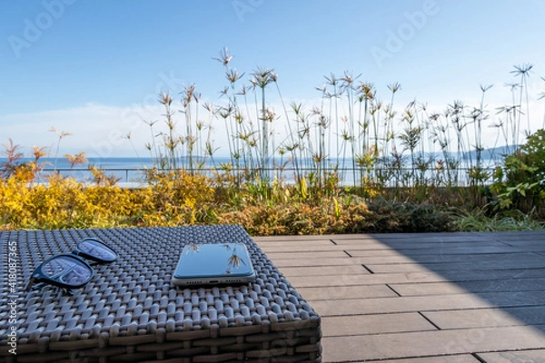 Fototapeta 海の見えるバルコニーで過ごすひと時　もしくはテレワーク　イメージ　seaside balcony with smartphone and glasses