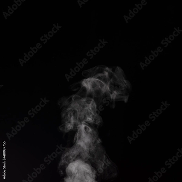 Fototapeta Curly white steam rising up and splashing water scattering in different directions isolated on a black background.