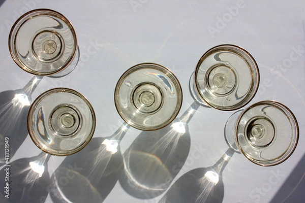Fototapeta Overhead view of old-fashioned coupe, wide, flat shape glasses with golden champagne wine on white background. Hard light, shadows. 

