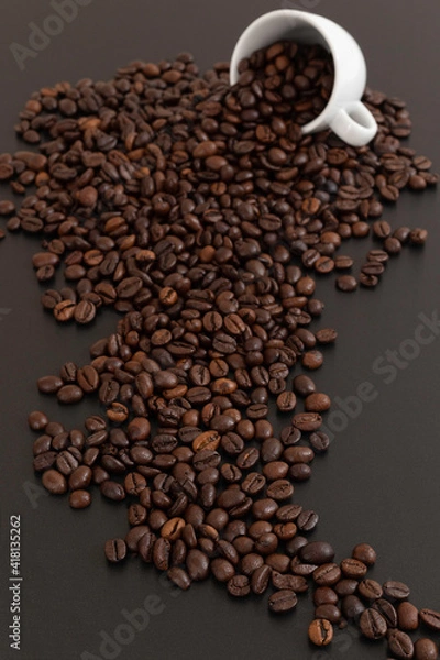 Fototapeta Grains de café sortant d'un tasse sur fond noir