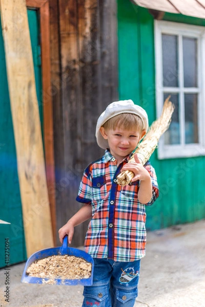 Fototapeta the child cuts wood with an axe and throws it into a pile