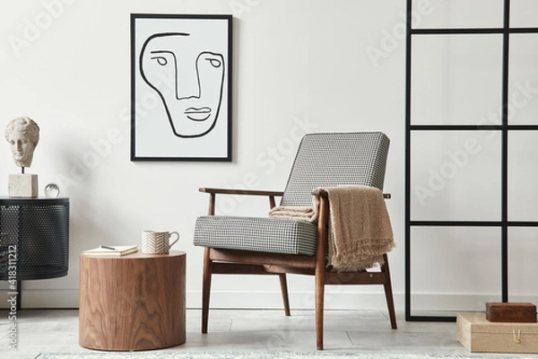 Fototapeta Stylish scandinavian composition of living room with design armchair, black mock up poster frame, commode, wooden stool, book, decoration, loft wall and personal accessories in modern home decor.