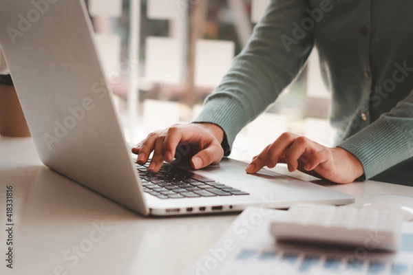 Fototapeta Business woman working and typing on laptop computer on the table.