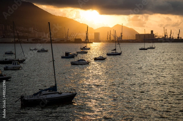 Obraz Bright sunset over the sea with sailboats at anchor in the harbor