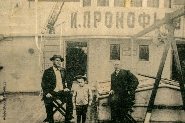 Fototapeta Russia, Caspian Sea - CIRCA 1910-1917: Family members of a ship crew posing on the Ivan Prokofjev oil tanker ship which was used for transporting unrefined crude oil from extraction to refineries