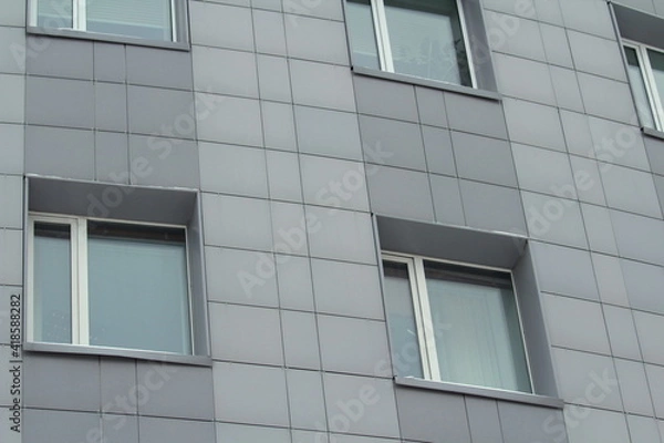 Fototapeta Plastic windows in a modern gray tiled brick high-rise house. Bottom view. Stock photo modern urban development for web and print.
