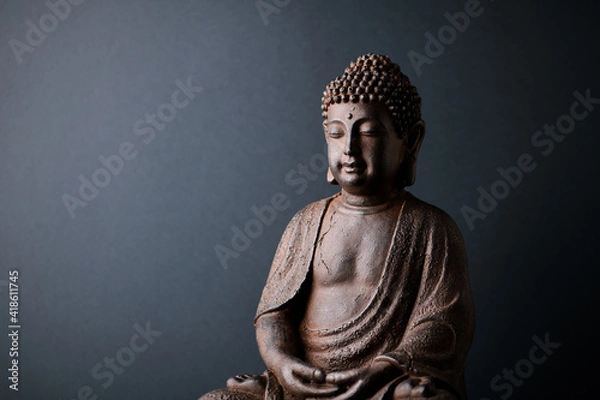 Fototapeta Meditating Buddha Statue on paper background. Copy space.