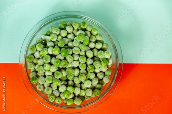 Obraz bowl with frozen peas on orange and light blue background