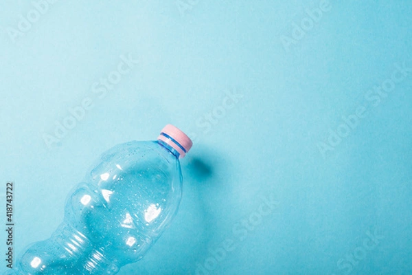 Fototapeta Plastic bottles crushed on the blue background. Recycling concept