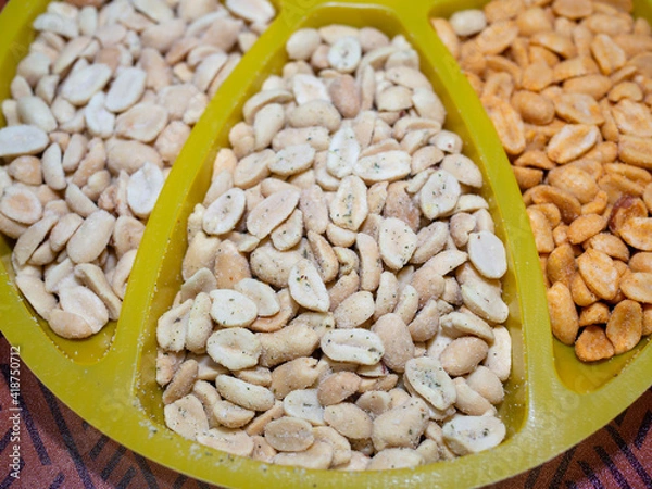 Fototapeta salted peanuts with different flavors on the table in a bowl. beer snack