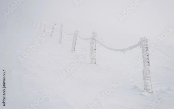 Fototapeta Snow covered signposts on the mountainside.