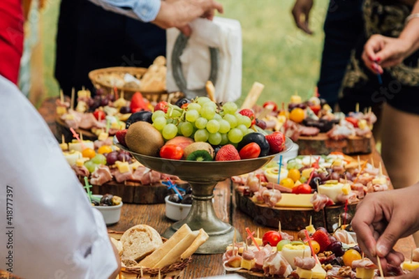 Obraz Bandeja con frutas en una mesa de banquete con otros alimentos alrededor