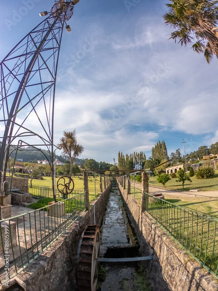 Fototapeta Traditional, old fashioned water pumping ranch windmill in a large mansion estate near Esposende, Portugal. Old Farm windmill for pumping water with spinning blades.