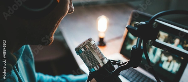 Obraz Young host streaming his live podcast using professional microphone at small broadcast studio