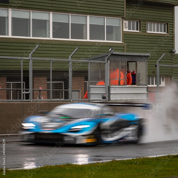 Fototapeta A shot of a racing car as it circuits a track.