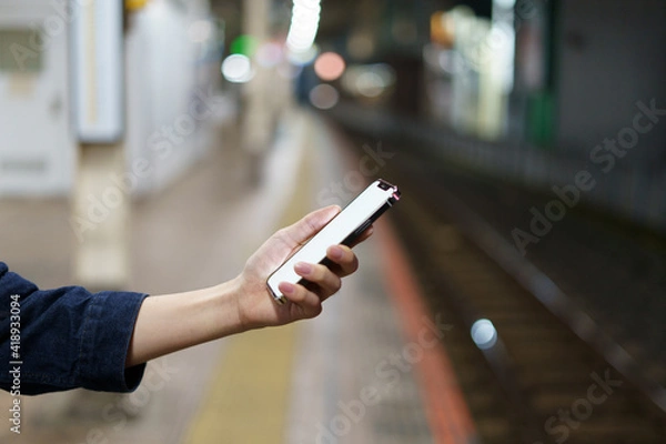 Fototapeta 夜の街スマートフォンと手