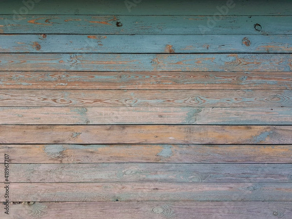 Fototapeta Texture of old wooden planks arranged horizontally with faded blue paint. Without people. Old village house made of wooden planks, with peeling paint. As a background or desktop wallpaper. 