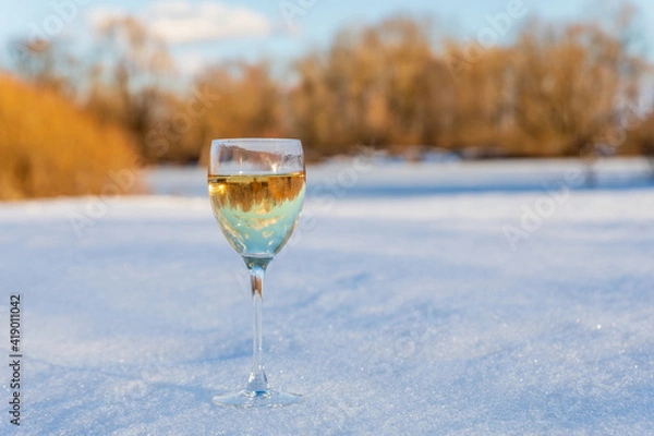 Fototapeta A glass of wine stands in the snow .