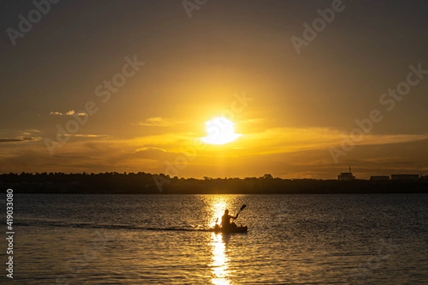 Obraz remando no pôr do sol
