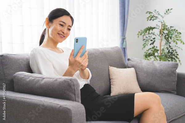 Obraz 携帯を持つミドル女性