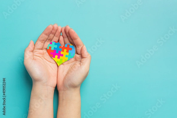 Obraz child hands holding jigsaw puzzle heart shape, Autism Day