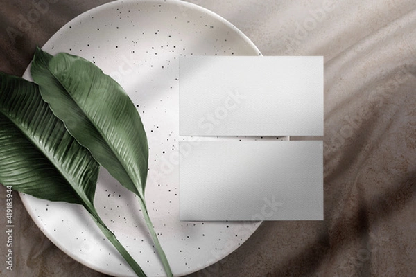 Fototapeta Clean minimal business card mockup on plate with leaves and fabric