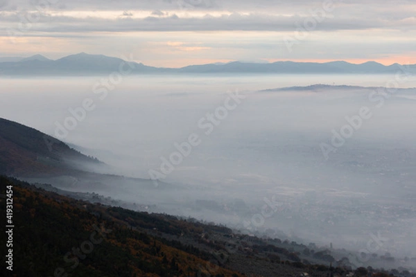 Fototapeta Mist and fog between valley and layers of mountains and hills at dusk, in Umbria (Italy)
