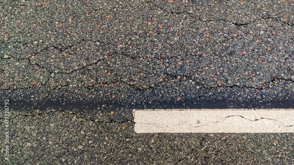 Fototapeta Asphalt road with white marking line, texture with cracks 