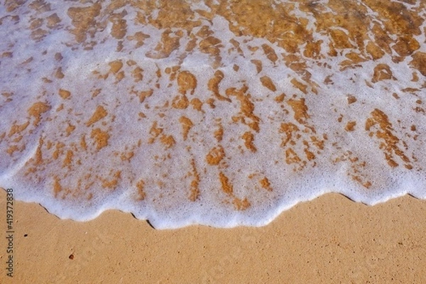 Fototapeta Sand beach with white sea soft foam wave on top view in thailand for assembling an article about travel in summer holiday or ocean sand beach coast nature.