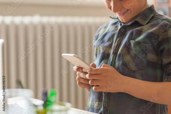 Fototapeta Close up of a boy text messaging on smart phone.